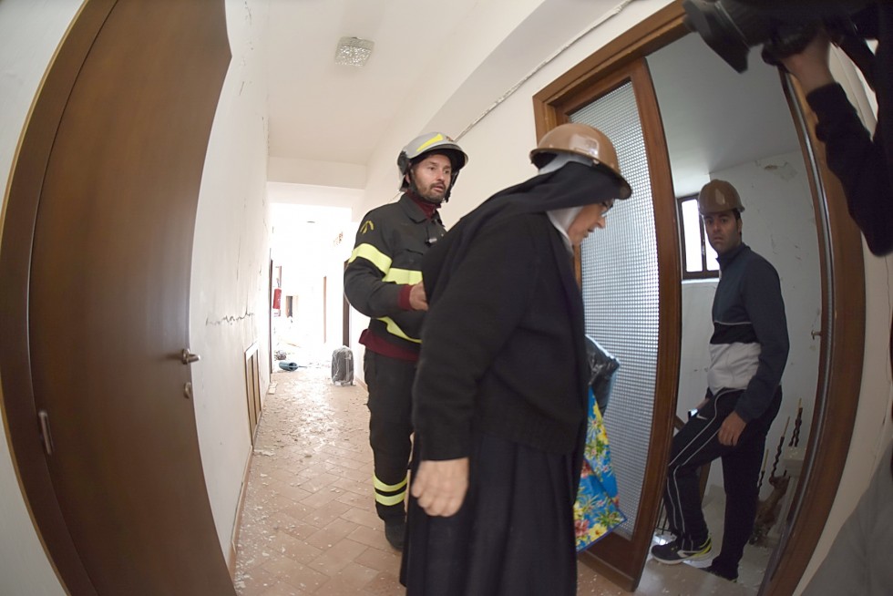 Norcia, 2 novembre 2016: terremoto - suora con vigile del fuoco dentro monastero crollato